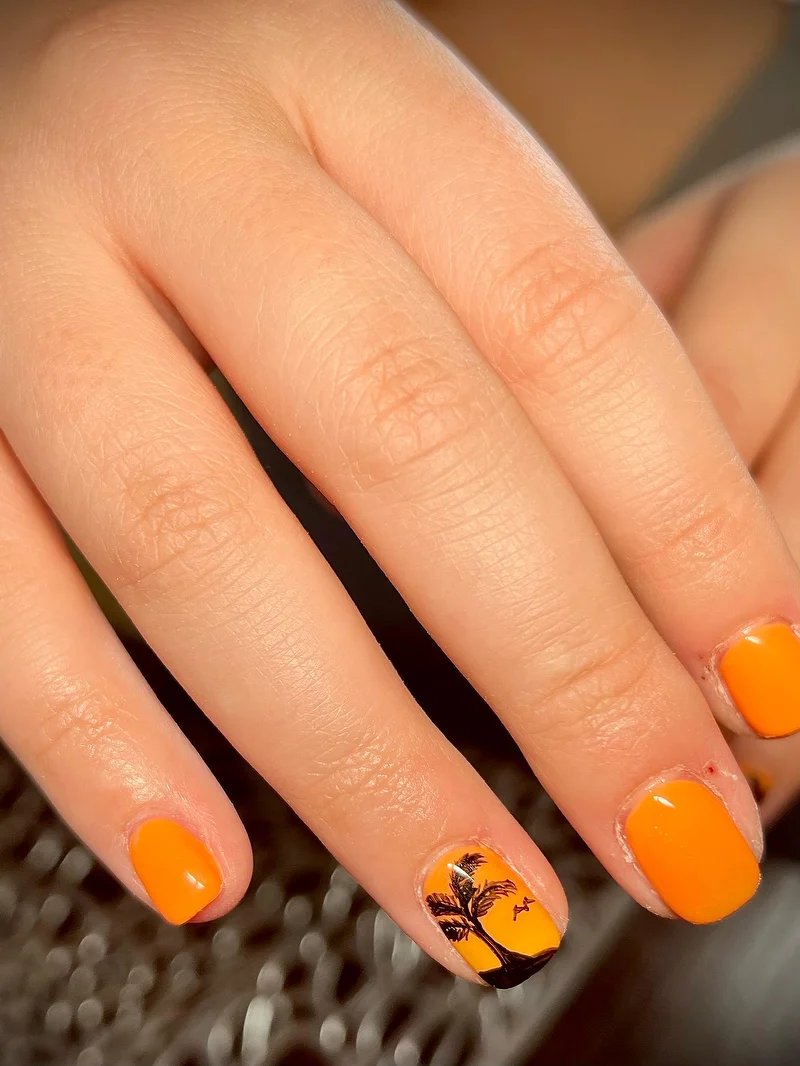 Orange nails with palm tree holiday design